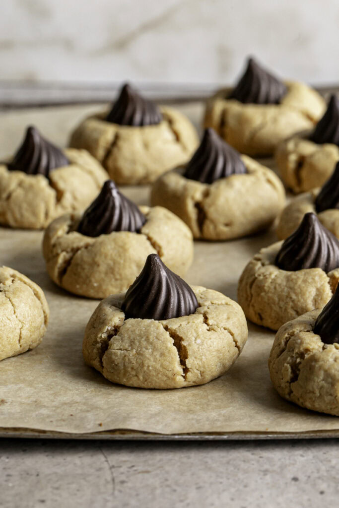 Almond Flour Peanut Butter Blossom Cookies on a parchment lined baking sheet