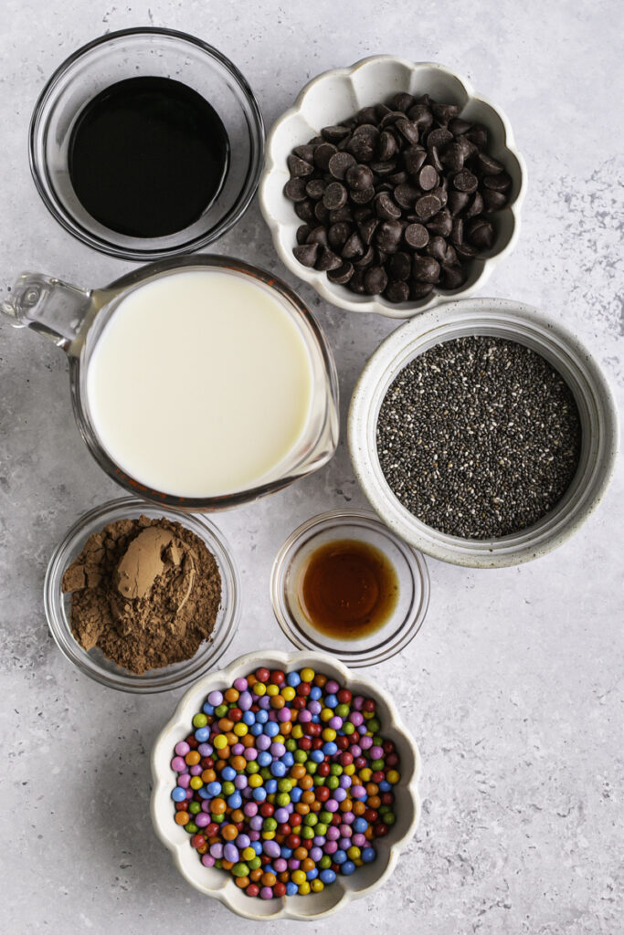 all of the ingredients used to make cosmic brownie chocolate chia seed pudding in separate bowls.
