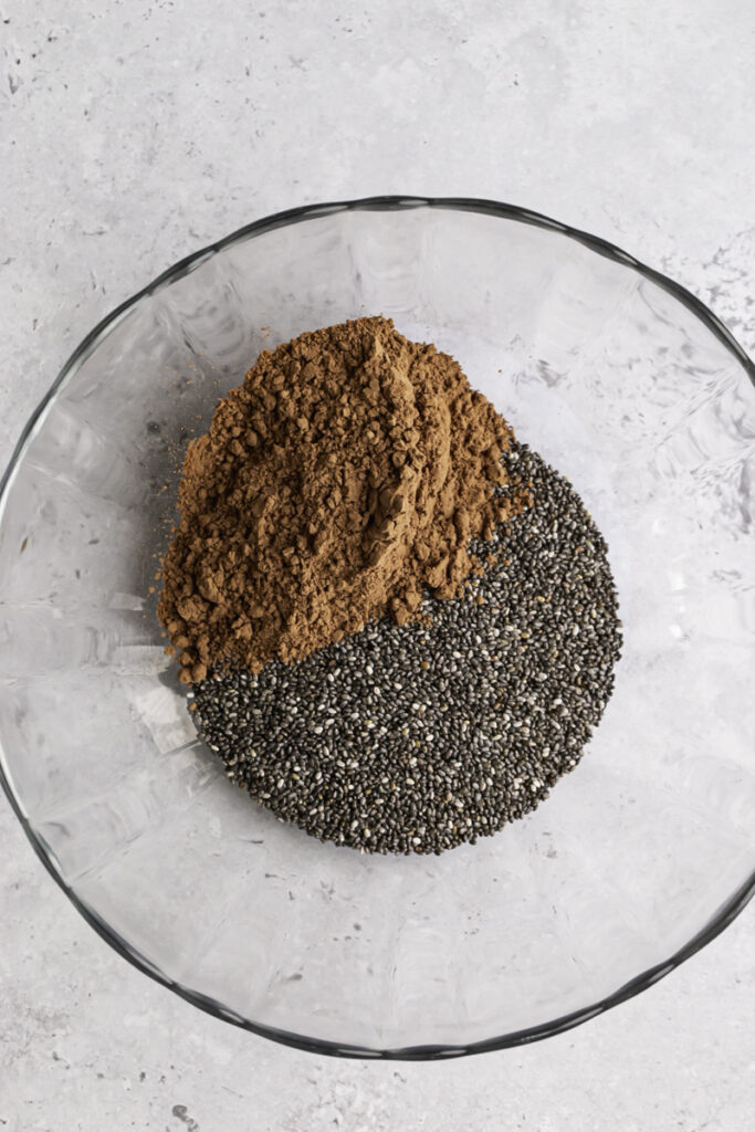 a glass bowl with chia seeds and cacao powder in it.