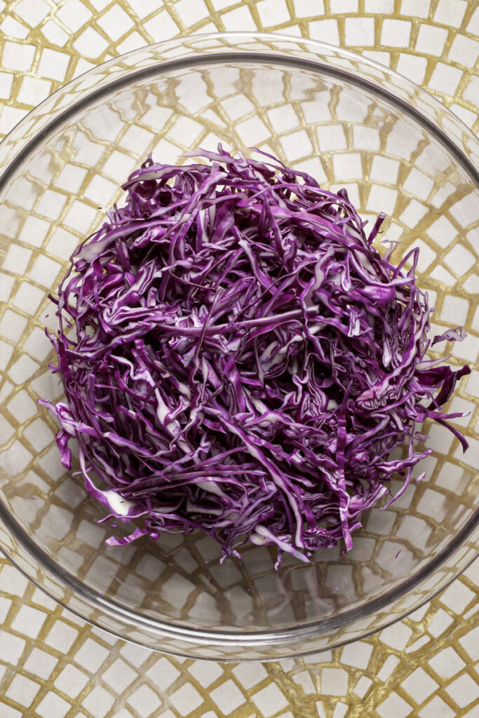 shredded coleslaw in a large glass bowl.
