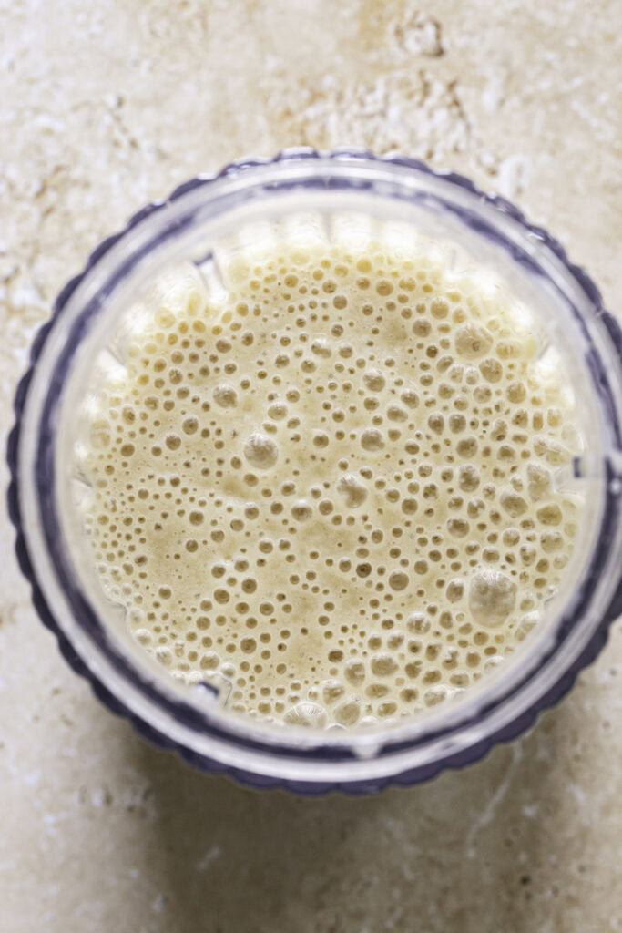 overhead shot of blended banana milk in a blender.