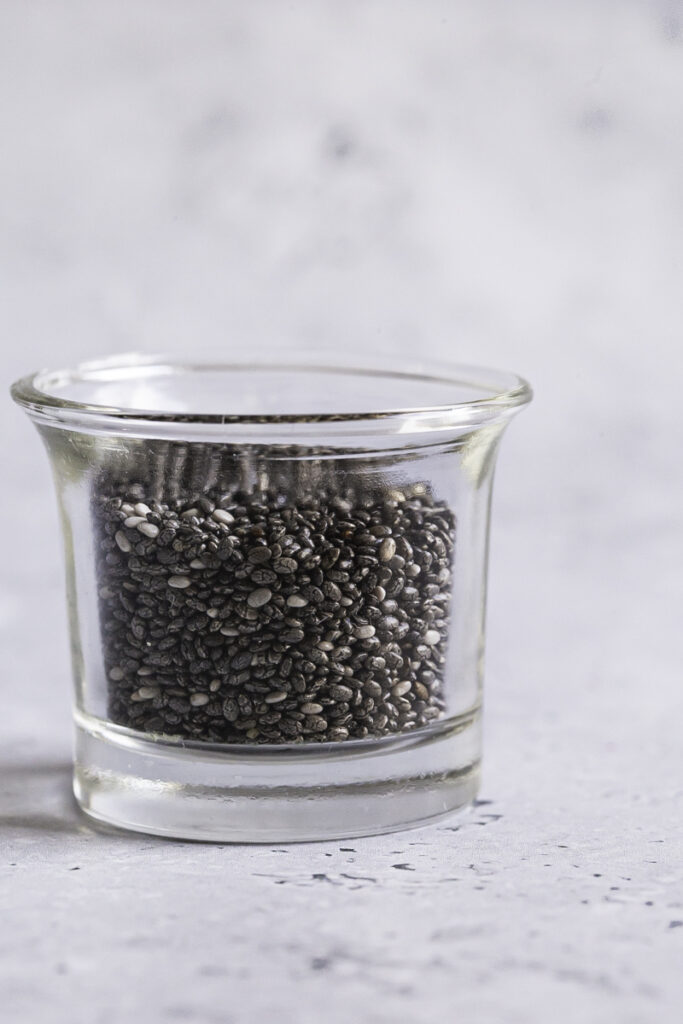 a small glass filled with black chia seeds.