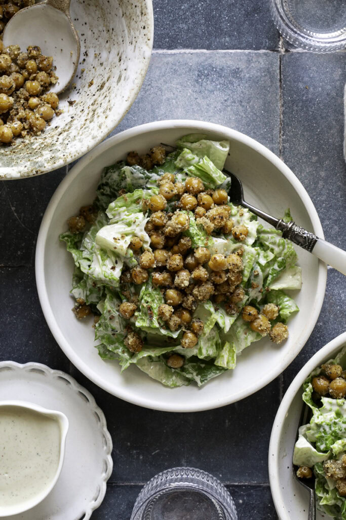 overhead shot of romaine caesar salad garnished with crispy chickpea croutons.