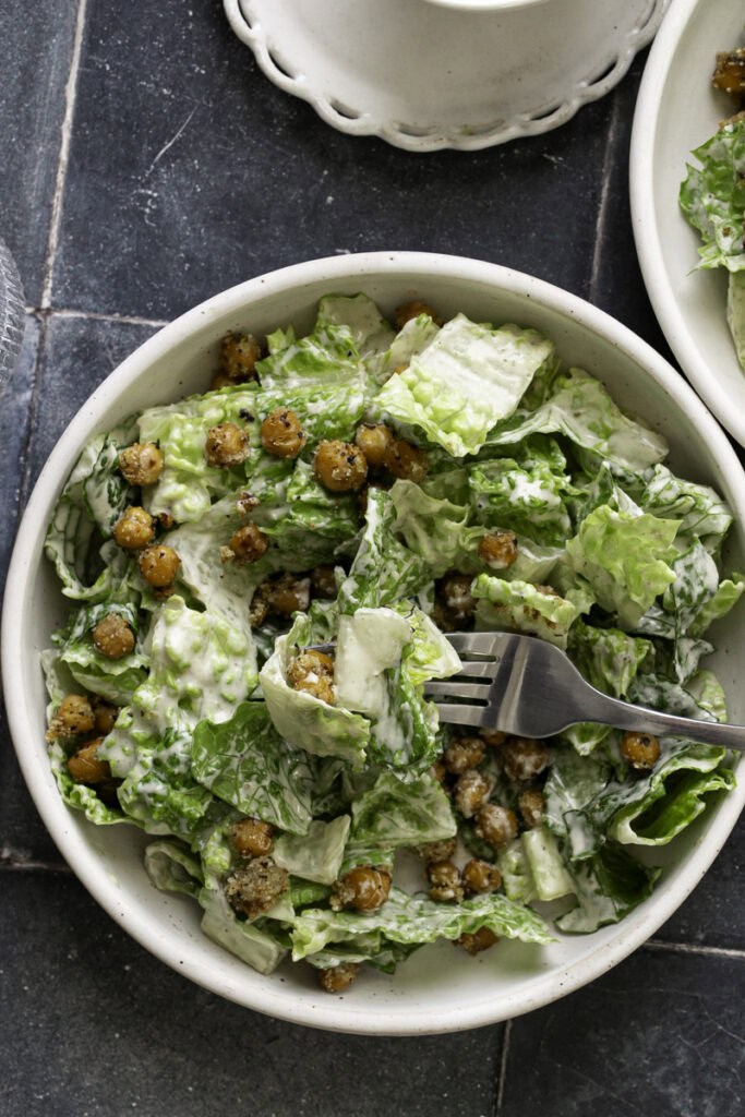 romaine caesar salad with a fork in it.