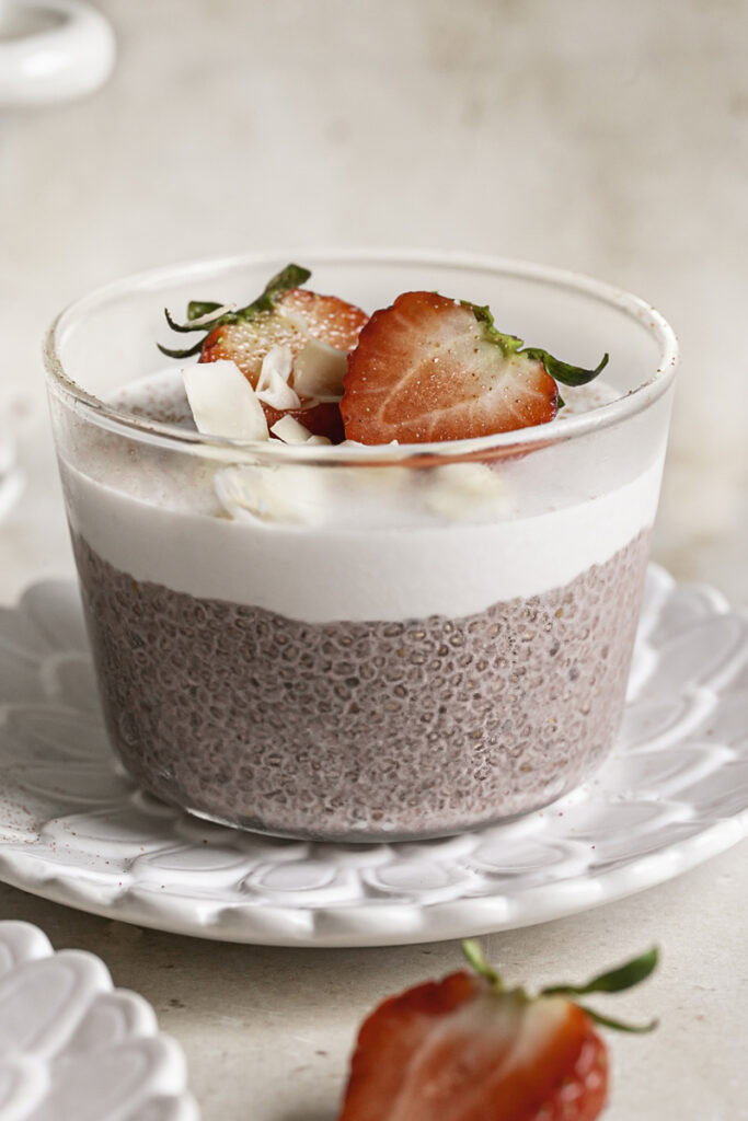 a very close up image of one glass of strawberry hibiscus chia seed pudding.