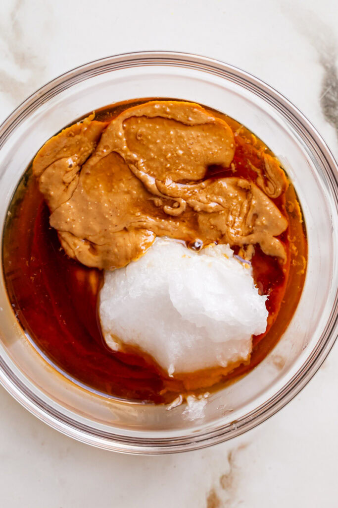 peanut butter, coconut oil, maple syrup, and vanilla extract in a glass bowl.