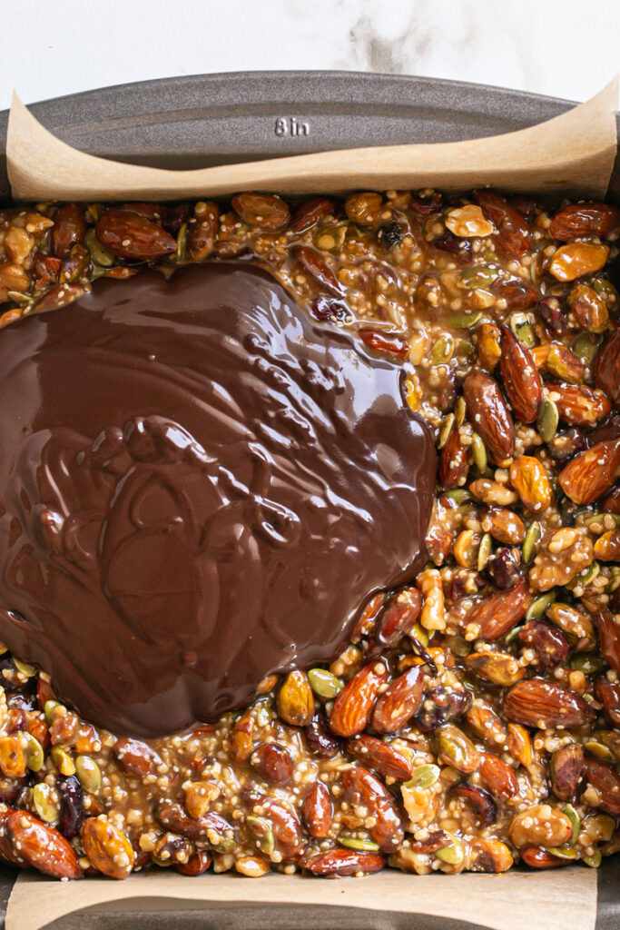 melted chocolate poured on top of the trail mix bars.