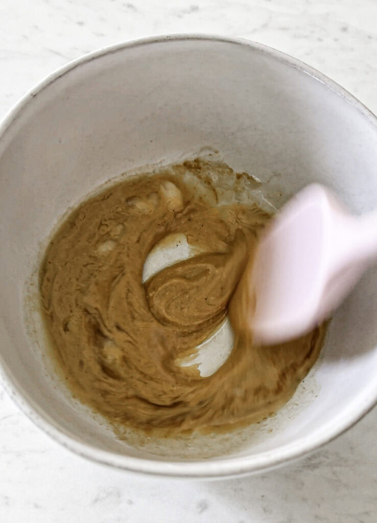 melted peanut butter mixture being stirred with a spatula.