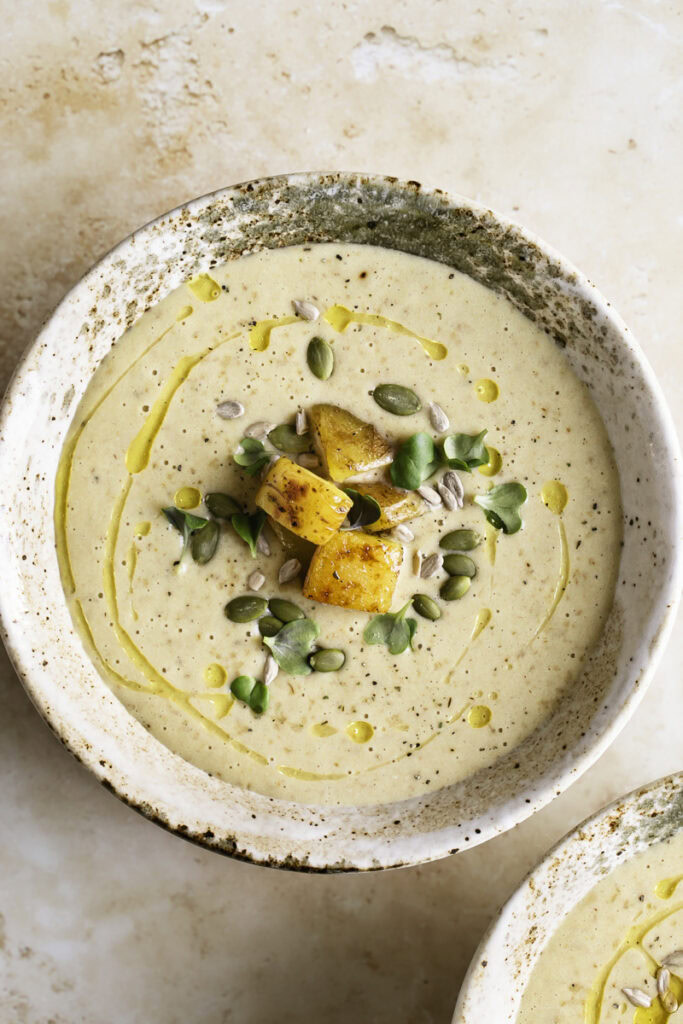 overhead shot of a bowl of Creamy Roasted Gold Potato Leek Soup.