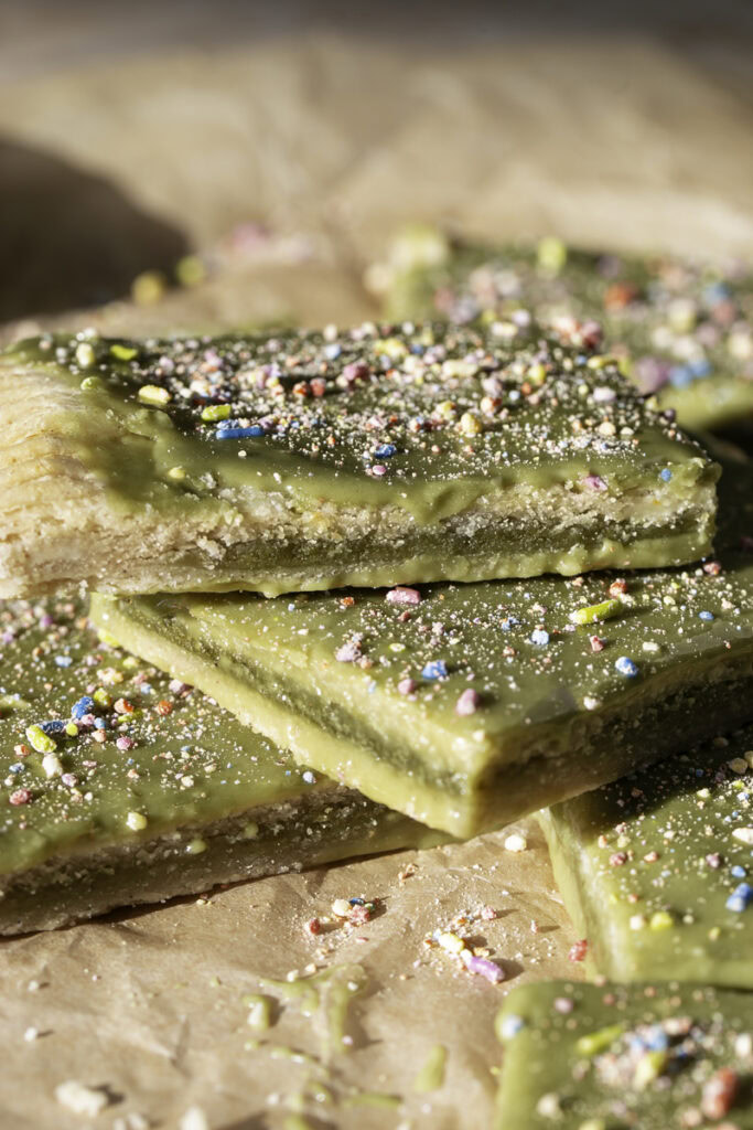 close up slices of giant frosted matcha pop tart stacked on top of one another.