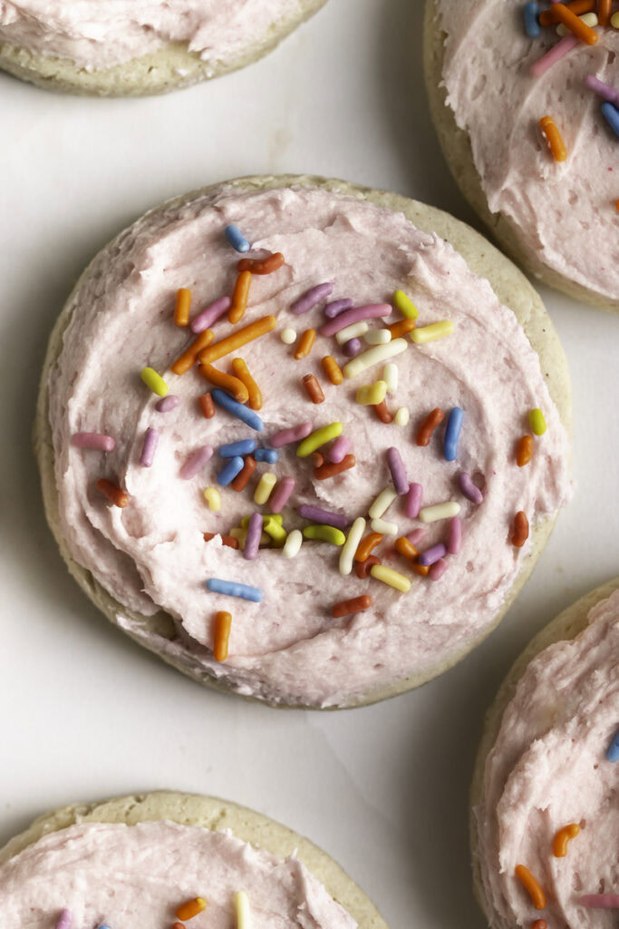 close up of a soft frosted and sprinkled sugar cookie.