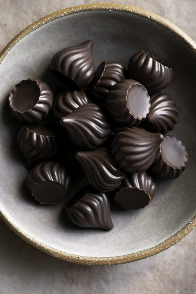 chocolate candy kisses piled on top of one another in a bowl.