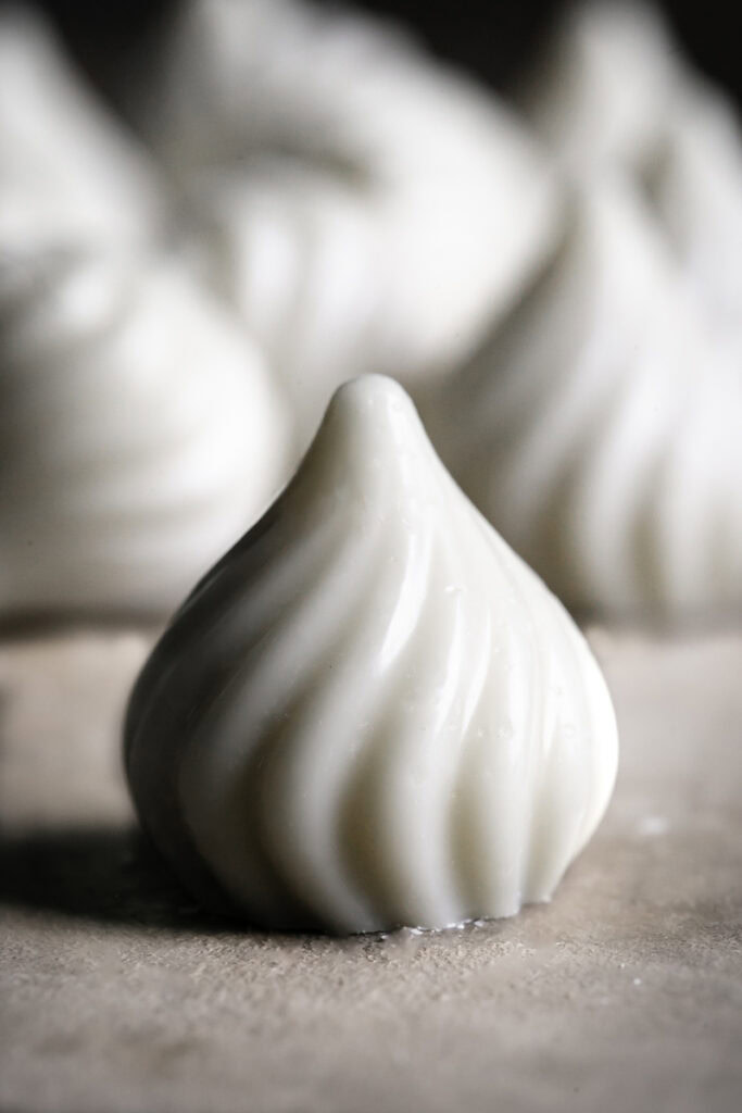 a single white chocolate candy with others in the background.