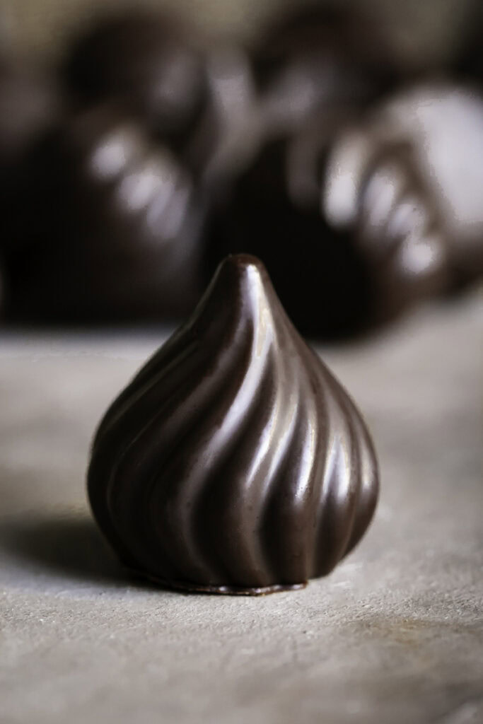 a single chocolate candy with others in the background.